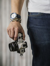 Midsection of man holding camera