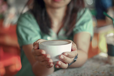 Midsection of woman drinking coffee