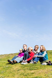 Friends sitting on grassy field