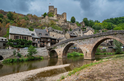 Arch bridge over river against sky