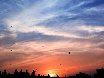 Low angle view of silhouette birds flying against sky