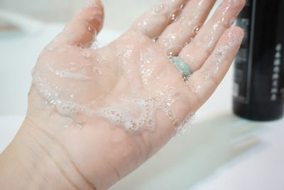 Close-up of woman hand covered with soap sud