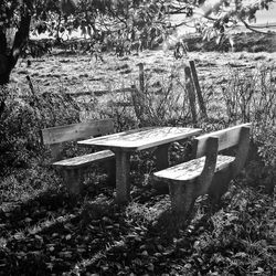 Empty chairs and table on field