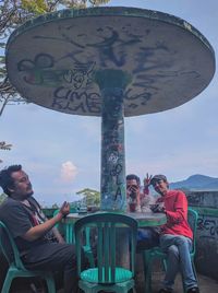 Group of people sitting against the sky