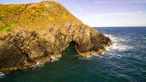 Rock formation in sea against sky