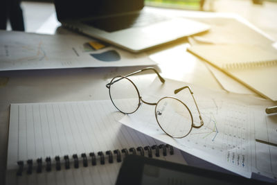 High angle view of eyeglasses with documents on table