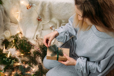 High angle view of woman holding christmas gift at home