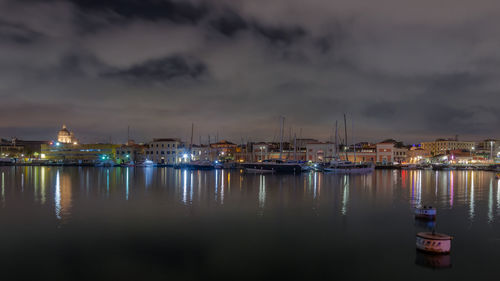 Boats moored in harbor at night