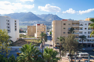 View of town by mountains against sky