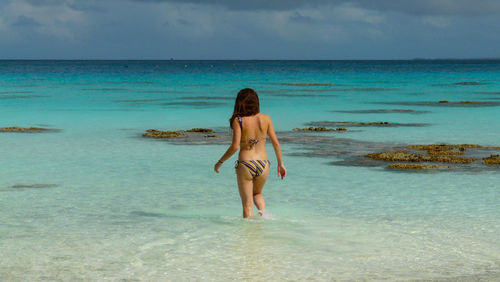 Full length of young woman standing at beach