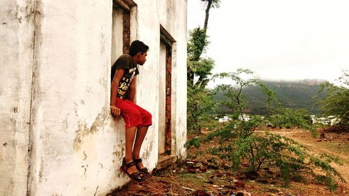 Side view of woman standing against trees