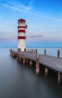 Lighthouse on sea against sky