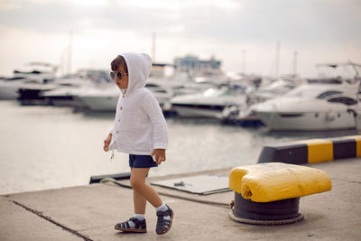 Boy child traveler stand on the marina with yachts in sochi in the summer