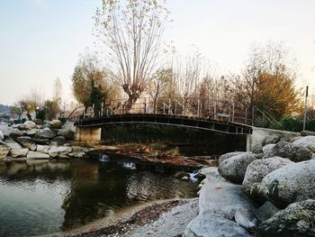 Footbridge over river against clear sky