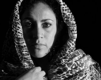 Close-up portrait of woman against black background