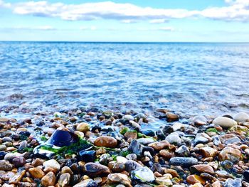 Surface level of pebbles at beach against sky