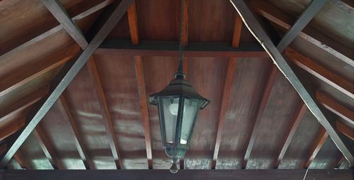 Low angle view of illuminated lights hanging on ceiling of building