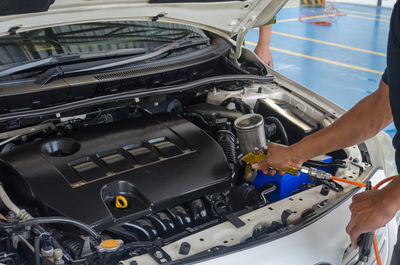 Cropped image of male mechanic repairing car in auto repair shop