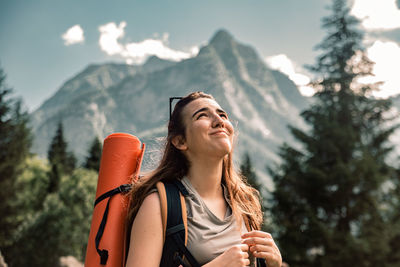 Young woman smiling against mountain range