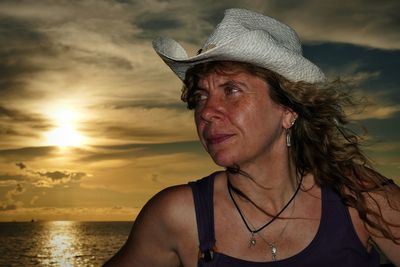 Portrait of woman wearing hat against sky during sunset