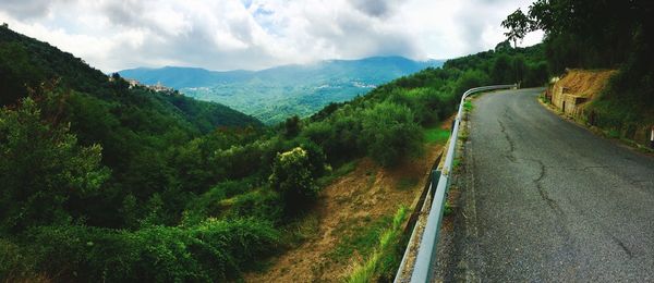 Panoramic view of road by mountains against sky