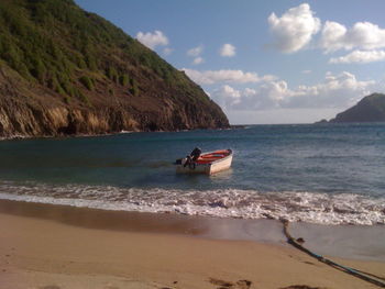 Motorboat at shore against sky