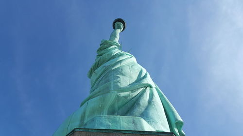 Low angle view of statue of liberty against blue sky