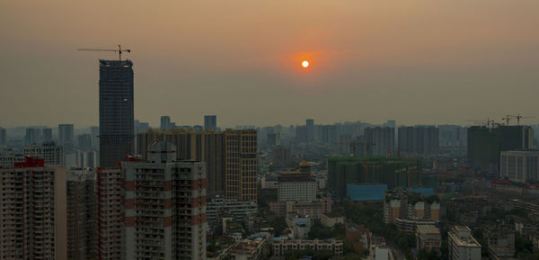 Buildings in city at sunset