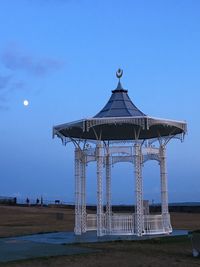 Gazebo on beach against clear blue sky