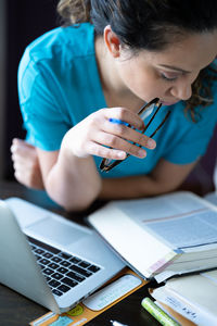Midsection of woman using mobile phone while sitting on table