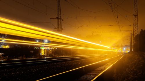 Light trails on railroad station platform at night