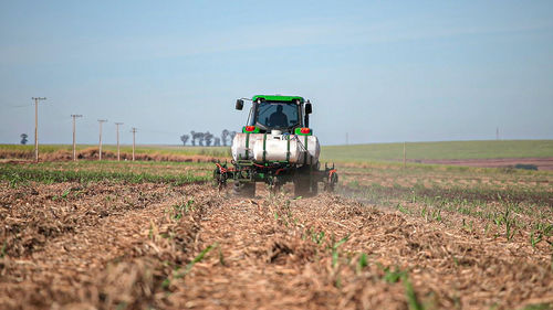 Tractor on agricultural field against sky