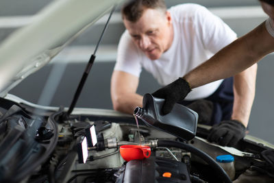 Midsection of man holding camera in car