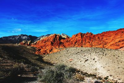 Scenic view of mountains against blue sky