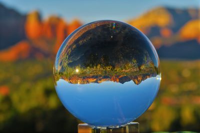 Close-up of crystal ball against sky