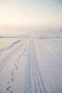 Snow covered land against sky