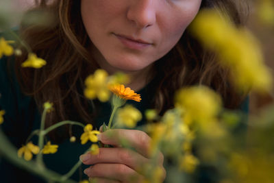 Close-up of woman with yellow flower