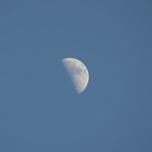 Low angle view of moon against clear blue sky