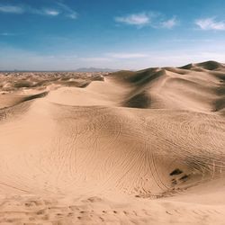 Scenic view of sand dunes against sky