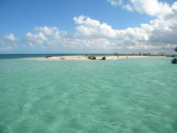 Scenic view of sea and island against cloudy sky