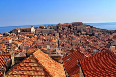 High angle view of townscape by sea against clear sky