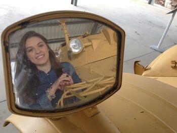 Reflection of beautiful woman in side-view mirror