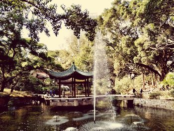 Gazebo in park by lake against sky