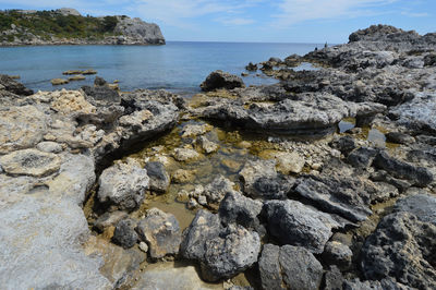 Rocks on beach against sky