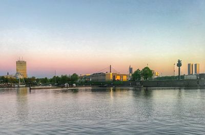 View of buildings at waterfront during sunset