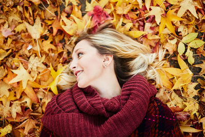 Young woman lying on autumn leaves