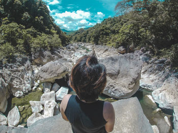 Rear view of woman on rock against mountains