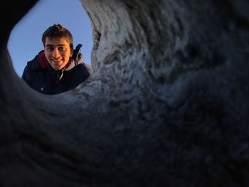 Portrait of smiling man seen from rock formation