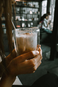 Close-up of hand holding glass of coffee