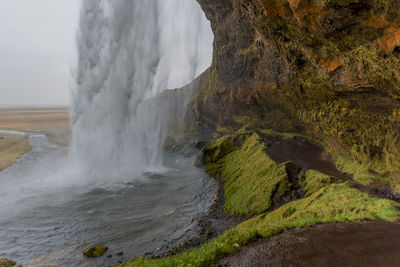 Scenic view of waterfall against sky